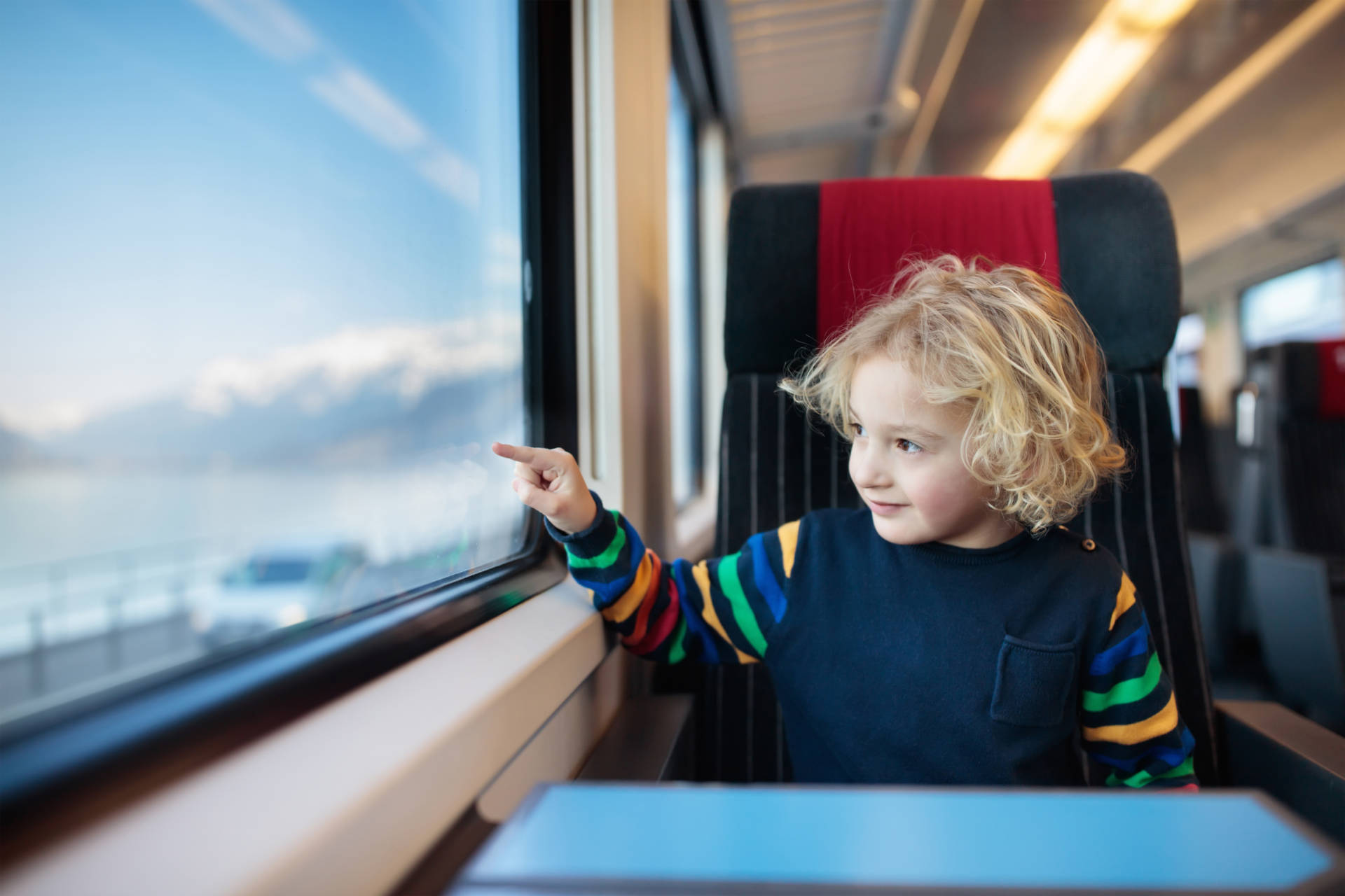 Child traveling by train. Little kid in a high speed express train on family vacation in Europe. Travel by railway. Children in railroad car. Kids in rail way wagon. Entertainment for young passenger.